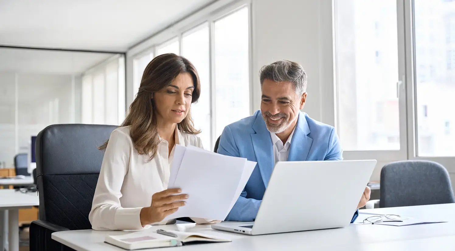 office coworkers looking at papers and a laptop