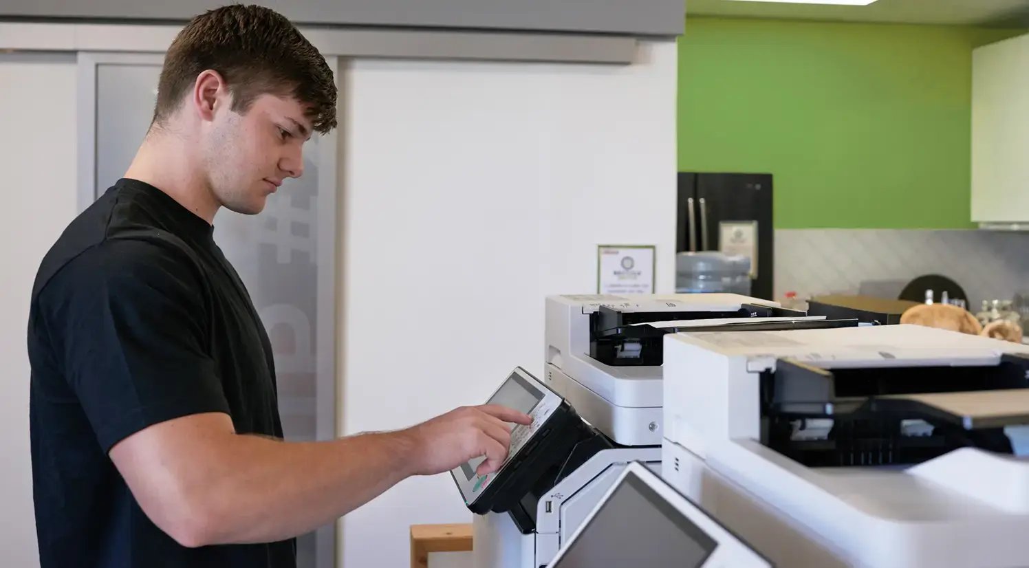 man in black sort sleeve shirt toggling printer settings